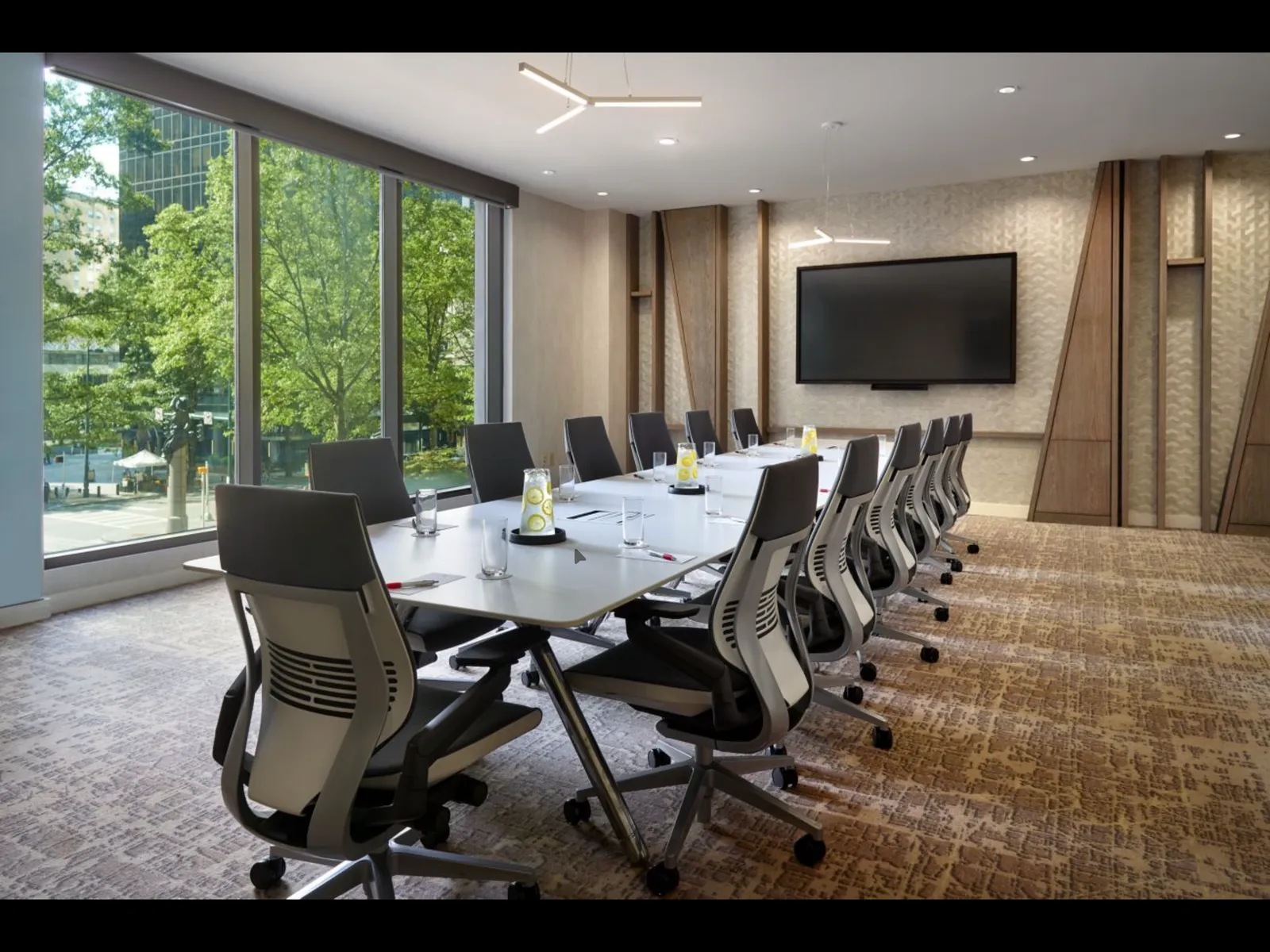 Clean modern office boardroom with conference table and city view