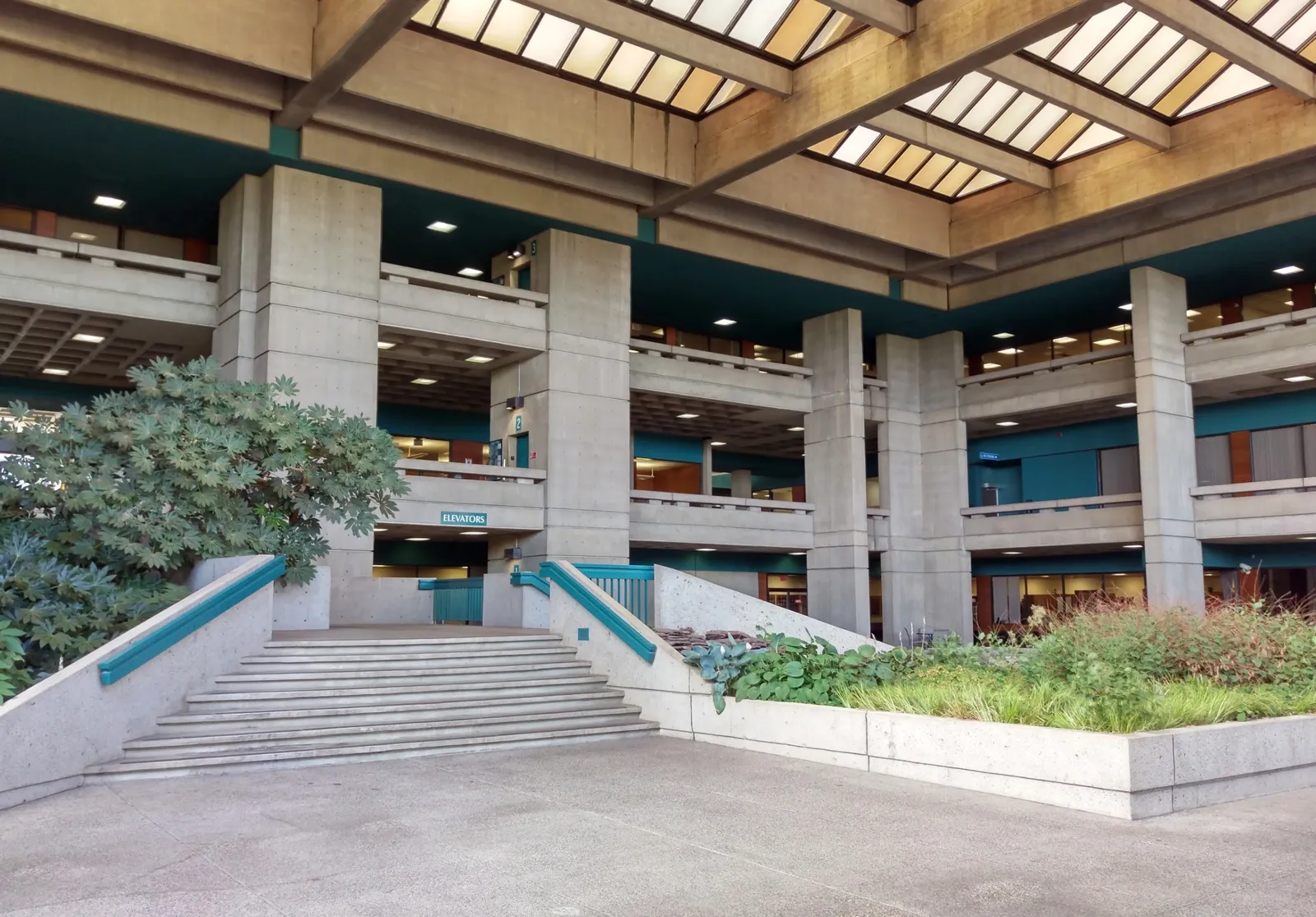 Multi-level government building interior with concrete and greenery